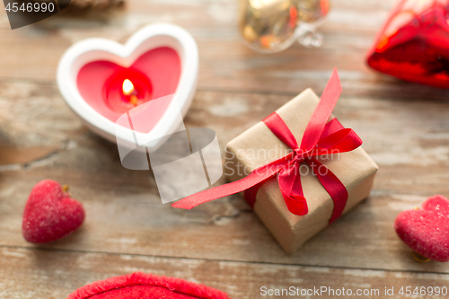 Image of christmas gift, heart shaped decorations, candle