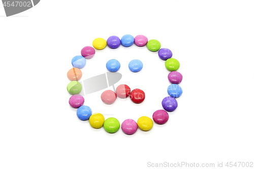 Image of Smiley from multicolored chocolate glazed candies on white