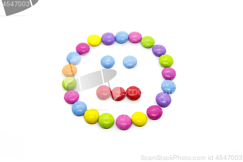 Image of Smiley from multicolored chocolate glazed candies on white