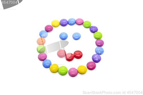 Image of Smiley from multicolored chocolate glazed candies on white