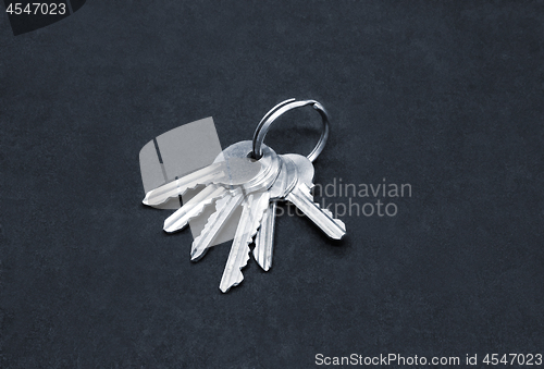 Image of Many silver keys on the ring on dark background