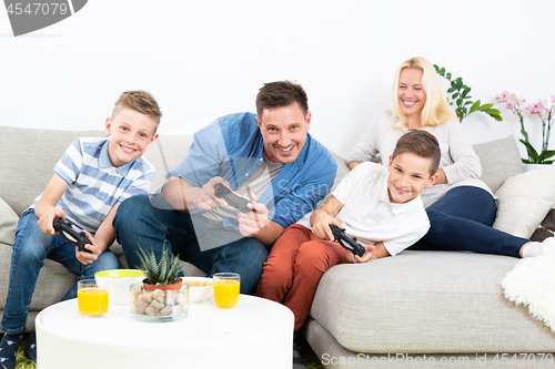 Image of Happy young family playing videogame On TV.