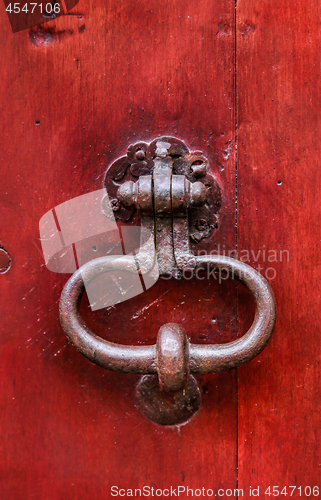 Image of Vintage bright red wooden door with metallic knocker