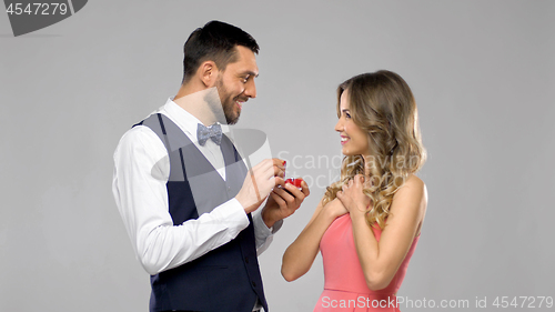 Image of happy man giving engagement ring to woman