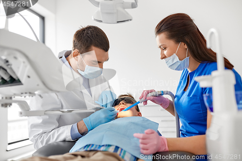 Image of dentist treating kid teeth at dental clinic