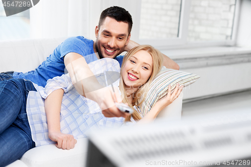 Image of happy smiling couple watching tv at home