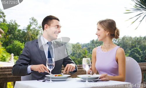 Image of smiling couple eating appetizers at restaurant