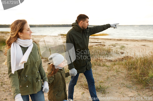 Image of happy family walking along autumn beach