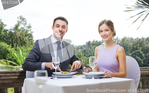 Image of smiling couple eating appetizers at restaurant