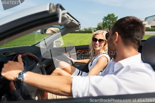 Image of happy man and woman driving in cabriolet car