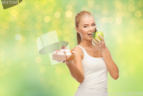 Image of happy woman eating apple instead of cake