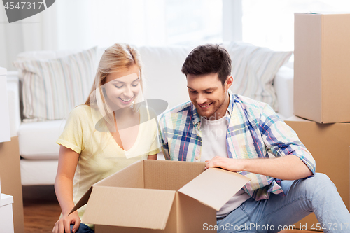 Image of happy couple unpacking boxes at new home