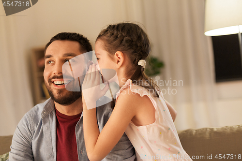 Image of happy daughter whispering secret to father at home