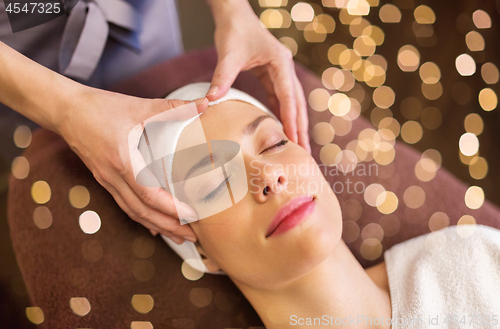 Image of woman having face and head massage at spa