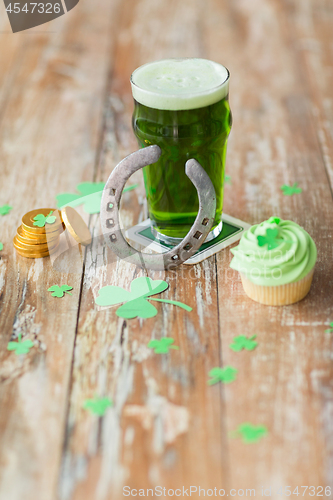 Image of glass of beer, cupcake, horseshoe and gold coins