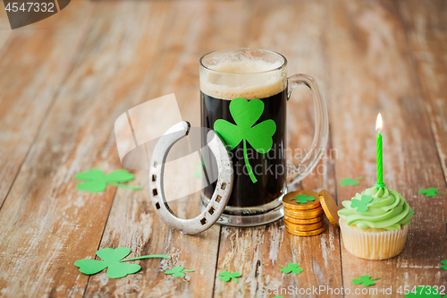 Image of glass of beer, horseshoe, green cupcake and coins