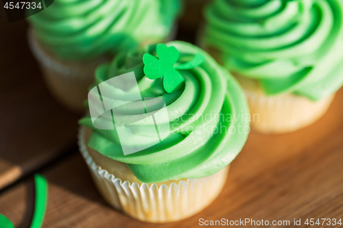 Image of green cupcakes and shamrock on wooden table