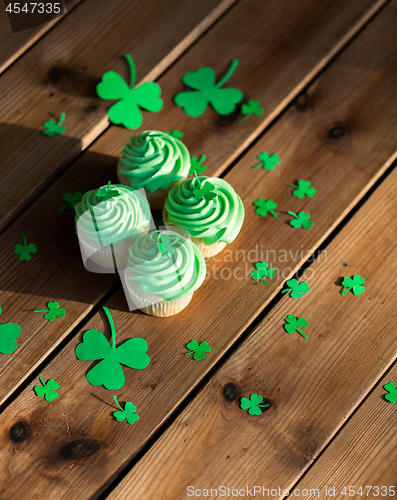 Image of green cupcakes and shamrock on wooden table