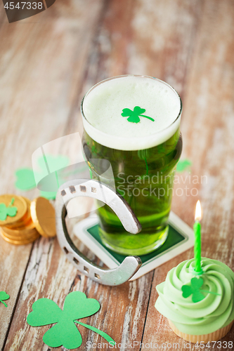 Image of glass of beer, cupcake, horseshoe and gold coins