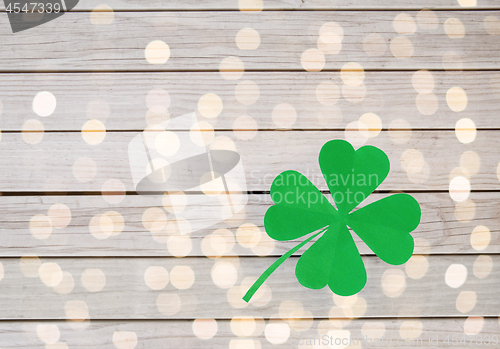 Image of green paper four-leaf clover on wooden background