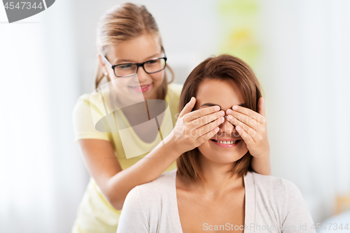 Image of happy mother and daughter playing guess who game