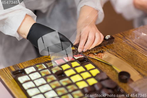 Image of worker packing candies at confectionery shop