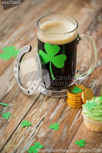 Image of shamrock on glass of beer, horseshoe and coins