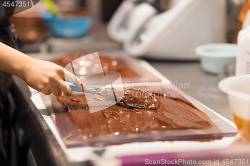 Image of confectioner makes chocolate dessert at sweet-shop