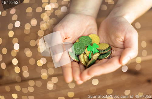 Image of hands with golden coins and shamrock leaf