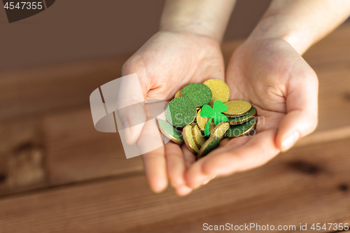 Image of hands with golden coins and shamrock leaf