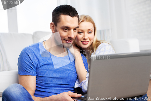 Image of happy couple with laptop computer at home