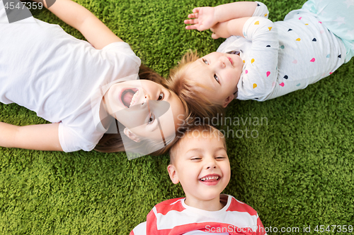 Image of happy little kids lying on floor or carpet