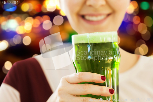 Image of close up of woman with green beer in glass