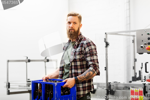 Image of man with bottles in box at craft beer brewery