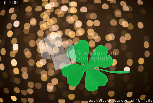 Image of green paper shamrock over festive lights