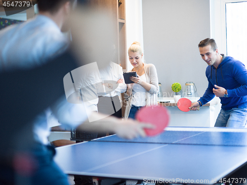 Image of startup business team playing ping pong tennis