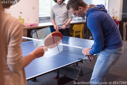 Image of startup business team playing ping pong tennis