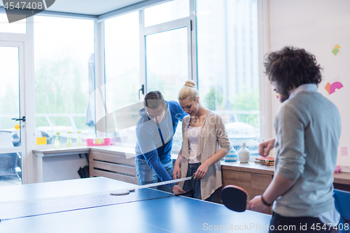 Image of startup business team playing ping pong tennis