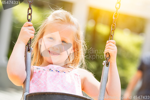Image of Pretty Young Girl Having Fun On The Swings At The Playground