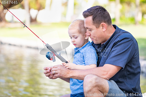 Image of Young Caucasian Father and Son Having Fun Fishing At The Lake