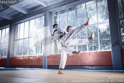 Image of Two judo fighters showing technical skill while practicing martial arts in a fight club