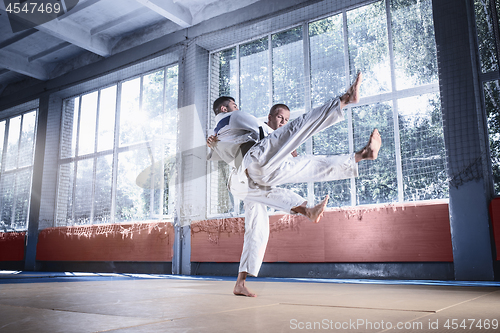 Image of Two judo fighters showing technical skill while practicing martial arts in a fight club