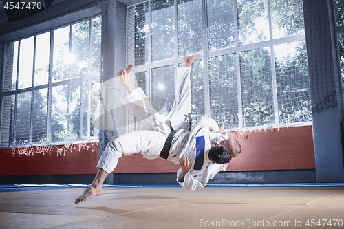 Image of Two judo fighters showing technical skill while practicing martial arts in a fight club