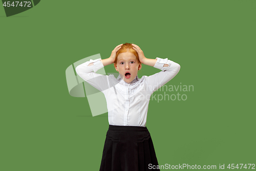 Image of Beautiful teen girl looking suprised isolated on green