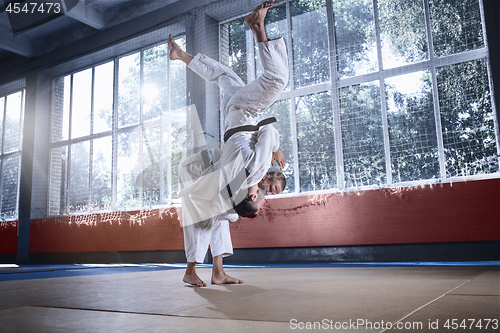 Image of Two judo fighters showing technical skill while practicing martial arts in a fight club