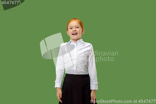 Image of The happy teen girl standing and smiling against p green background.