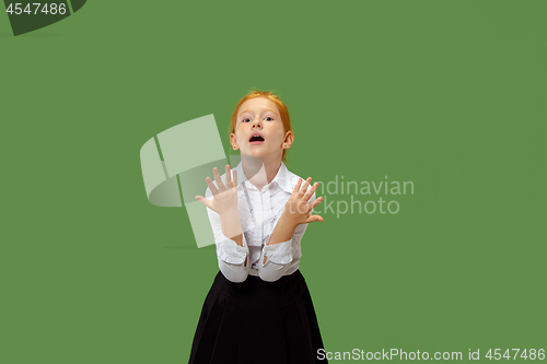 Image of Beautiful female half-length portrait on green studio backgroud. The young emotional teen girl