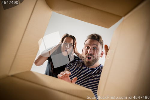 Image of The couple unpacking and opening carton box and looking inside