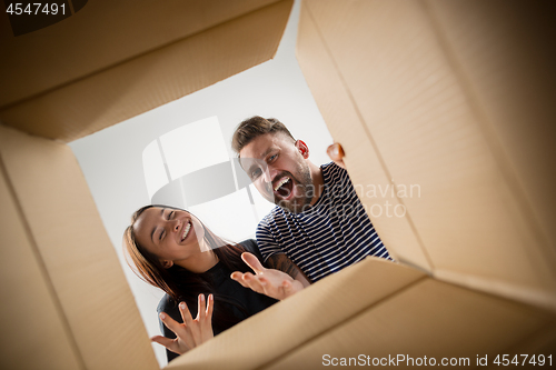 Image of The couple unpacking and opening carton box and looking inside