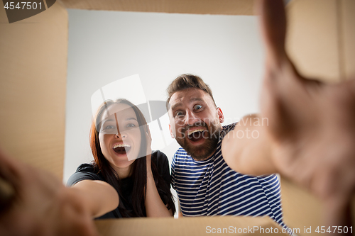 Image of The couple unpacking and opening carton box and looking inside